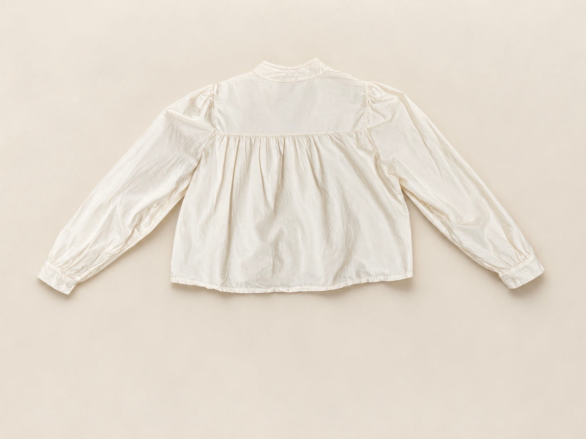 Blusa romántica beige con bordados y manga abullonada