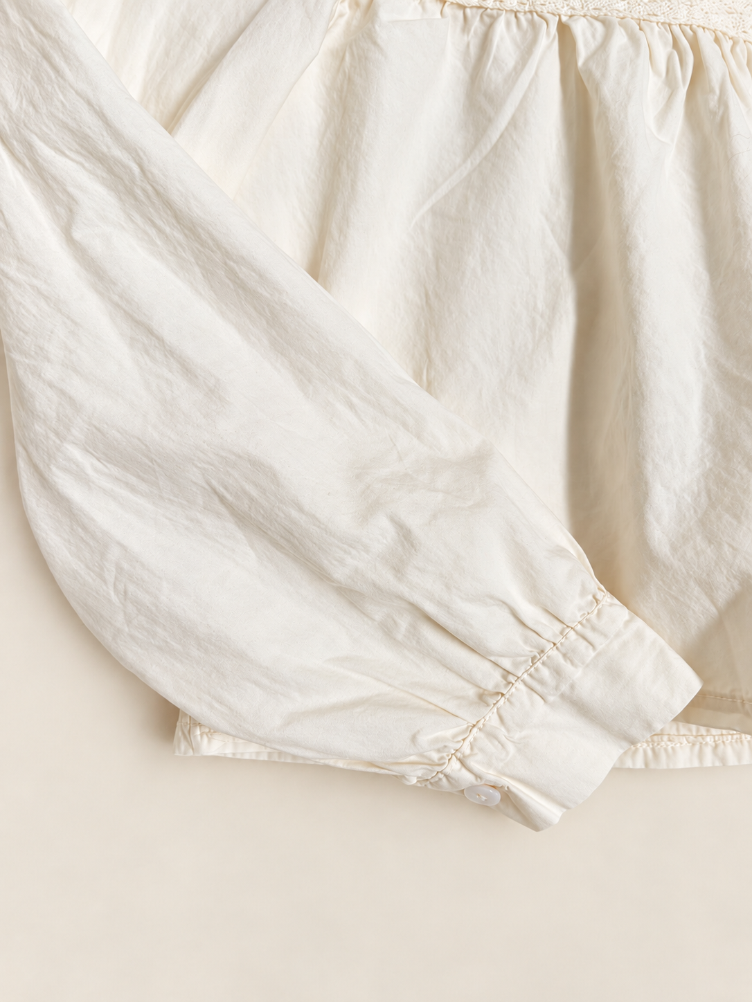 Blusa romántica beige con bordados y manga abullonada